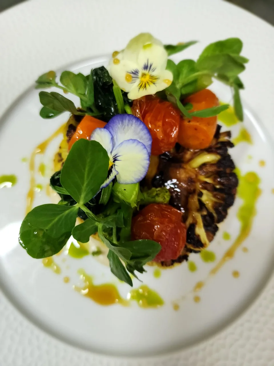 Elegant plated dish garnished with leaves and edible flowers